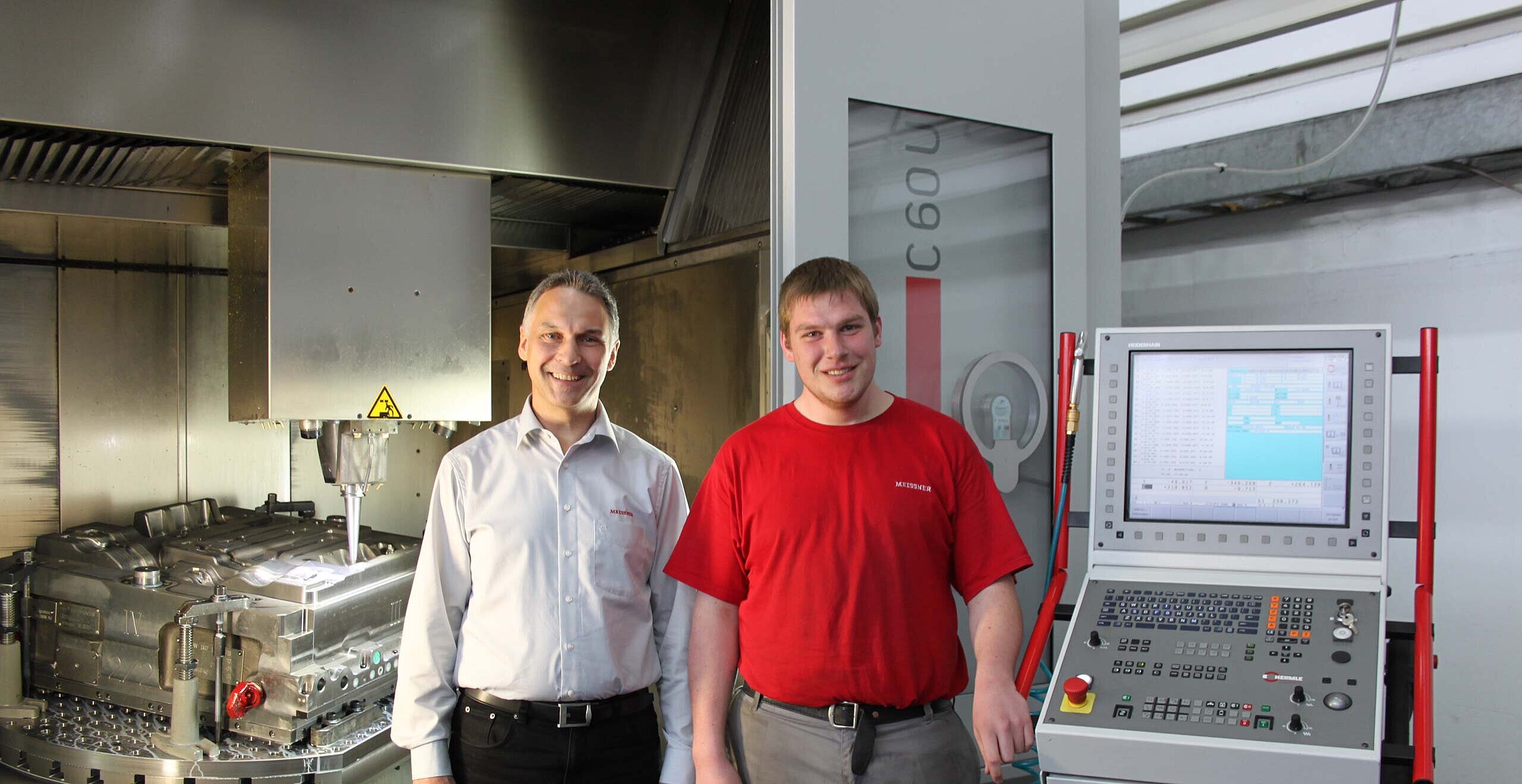 Von links Reinhard Hackler, Abteilungsleiter Mechanische Fertigung, und Lukas Garthe, Zerspanungsmechaniker, vor „seinem“ 5-Achsen-CNC-Hochleistungs- Bearbeitungszentrum C 60 U mit iTNC 530 HSCI Steuerung