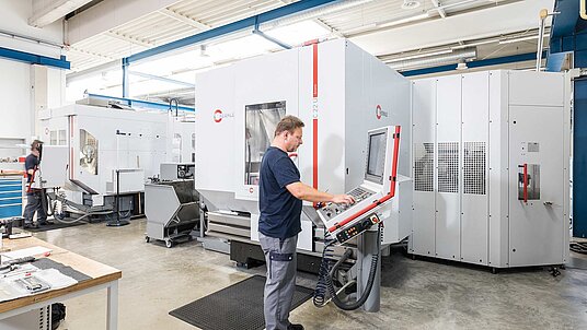 Das 5-Achsen-CNC-Hochleistungs-Bearbeitungszentrum C 22 U mit dem Zusatzmagazin ZM 43, betreut vom Fräser und Programmierer Stefan Heilek von GÜNTHER Heisskanaltechnik GmbH