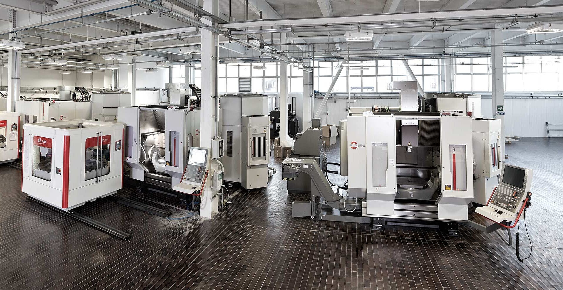 The three C 42 U five-axis machining centres already in operation on the left. The workpiece magazines on rails are in front of them, and on the right is the fourth C 42 U machining centre that is just being installed