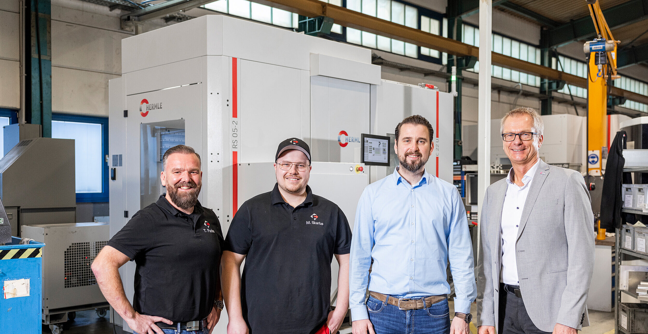 Mitarbeiter der Firma FWM vor ihrem HERMLE Bearbeitungszentrum C 22 mit Robotersystem RS 05-2