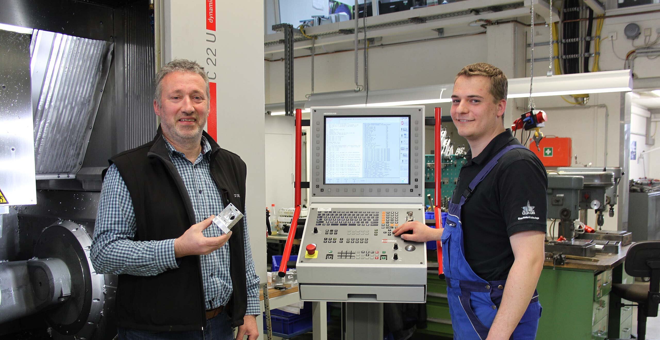Von links Uwe Wambach, Betriebsleiter, und rechts Andreas Theis, Industriemechaniker, beide von Oculus Optikgeräte GmbH in Wetzlar, vor dem 5-Achsen- CNC-Hochleistungs-Bearbeitungszentrum C 22 U von Hermle