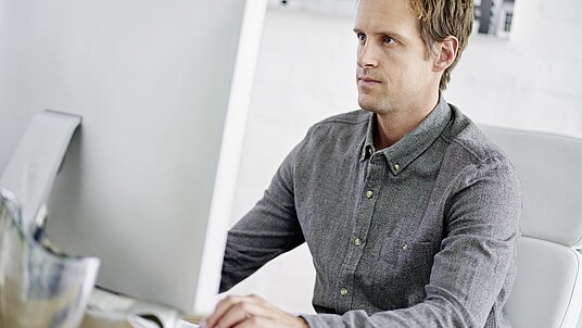 Mitarbeiter bedient PC mit CAD CAM System