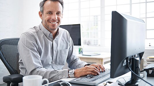 Mitarbeiter am PC am Schreibtisch mit CAD-CAM-Software