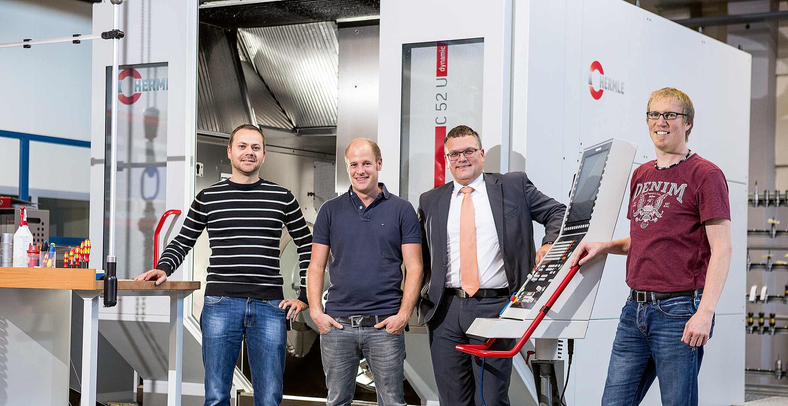 Gerhard Zech, Fachbereichsleiter Betriebsmittelbau, Markus Gapp, Leiter Fräsereigruppe, beide von Hirschmann Automotive GmbH, Florian König, Vertrieb Österreich/Südtirol bei der Maschinenfabrik Berthold Hermle AG, und Andreas Bolter, Leiter Werkzeugbau und Anlagenbau von Hirschmann Automotive GmbH, l, vor der C 52 U der Fräserei im Werk A-Rankweil