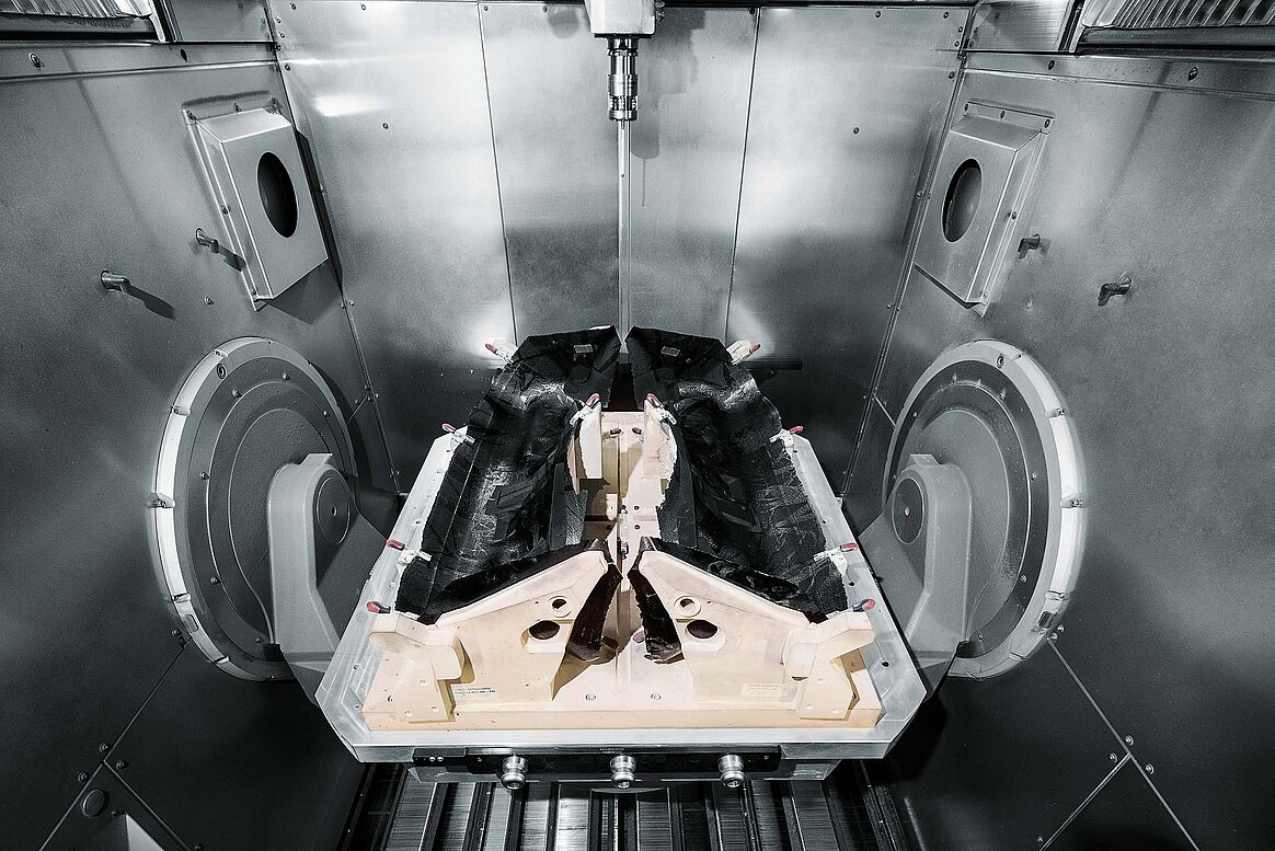 The working area of the Hermle 5 axis CNC high-power machining centre, together with the NC rotary table of diameter 1150 mm and a workpiece pallet with a composite workpiece which is being machined in a single clamping process