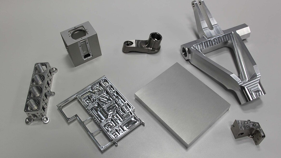 a small selection of typical workpieces milled from various solid materials, some on 5-axis machines