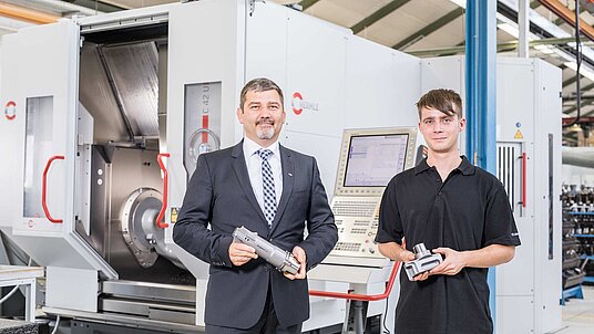 Hans Binder, Leiter Geschäftsbereich Präzisionswerkzeuge, und rechts Matthias Deuschle, Programmierung/Bedienung, vor dem 5-Achsen-CNC-Hochleistungs- Bearbeitungszentrum C 42 U