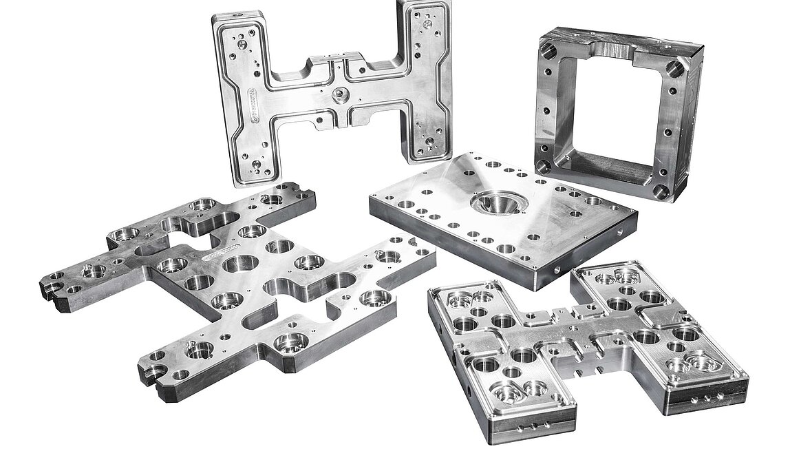 Heißkanal-Verteilersystemen und Werkzeugplatten, die auf Hermle-Bearbeitungszentren in 5-Achsen-Technologie allseitig und inklusive Tieflochbohren komplett bearbeitet werden