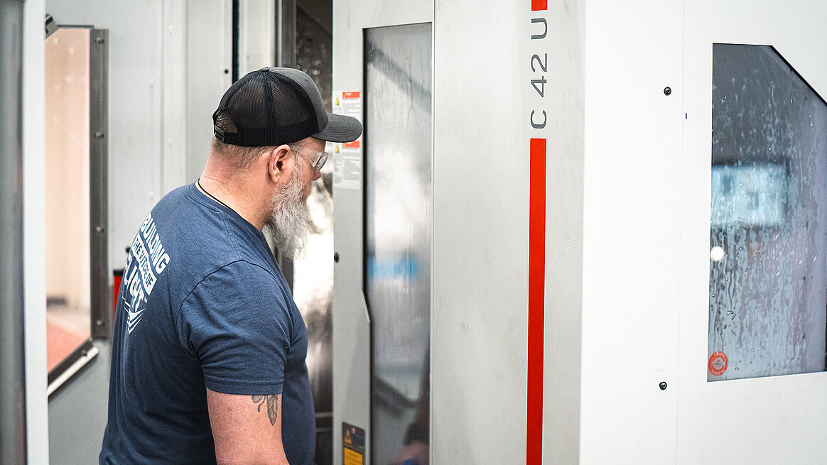 Seyer Industries 5-axis department lead, Jason Kinsler, inspects a part machined on the HERMLE C 42 U 5-axis CNC machine.