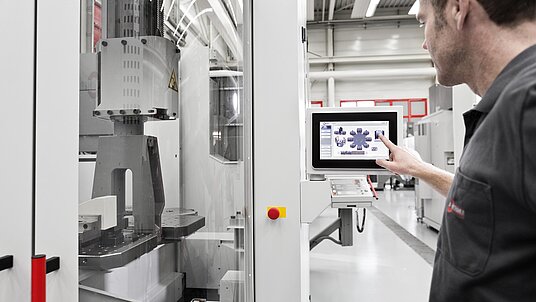 HERMLE Palettenwechsler Maschine wird bedient durch einen Mitarbeiter