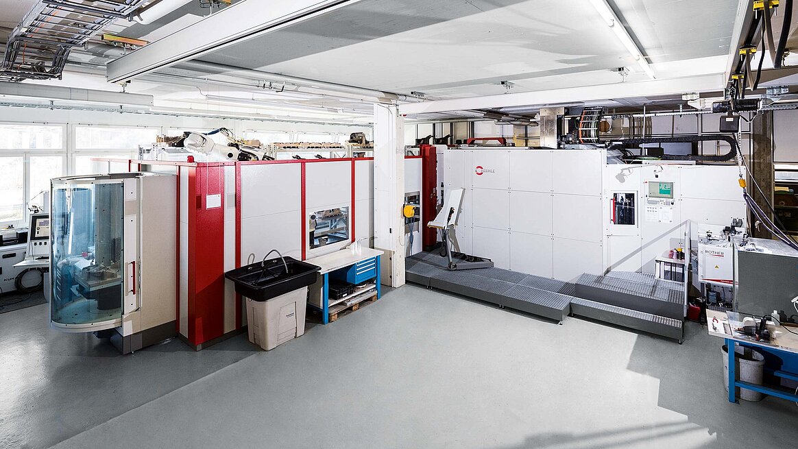 The flexible manufacturing system from Hermle AG in the house of the customer Connova AG in CH-Villmergen; right, the 5 axis CNC high-power machining centre C 50 U, left of which is the connected robot and workpiece magazine system RS3; on the far left is the workpiece/pallet setup station