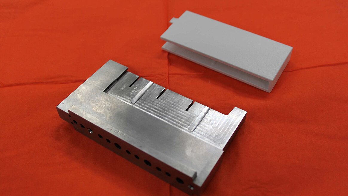 an MPA-manufactured tool insert and a cover flap manufactured using injection moulding